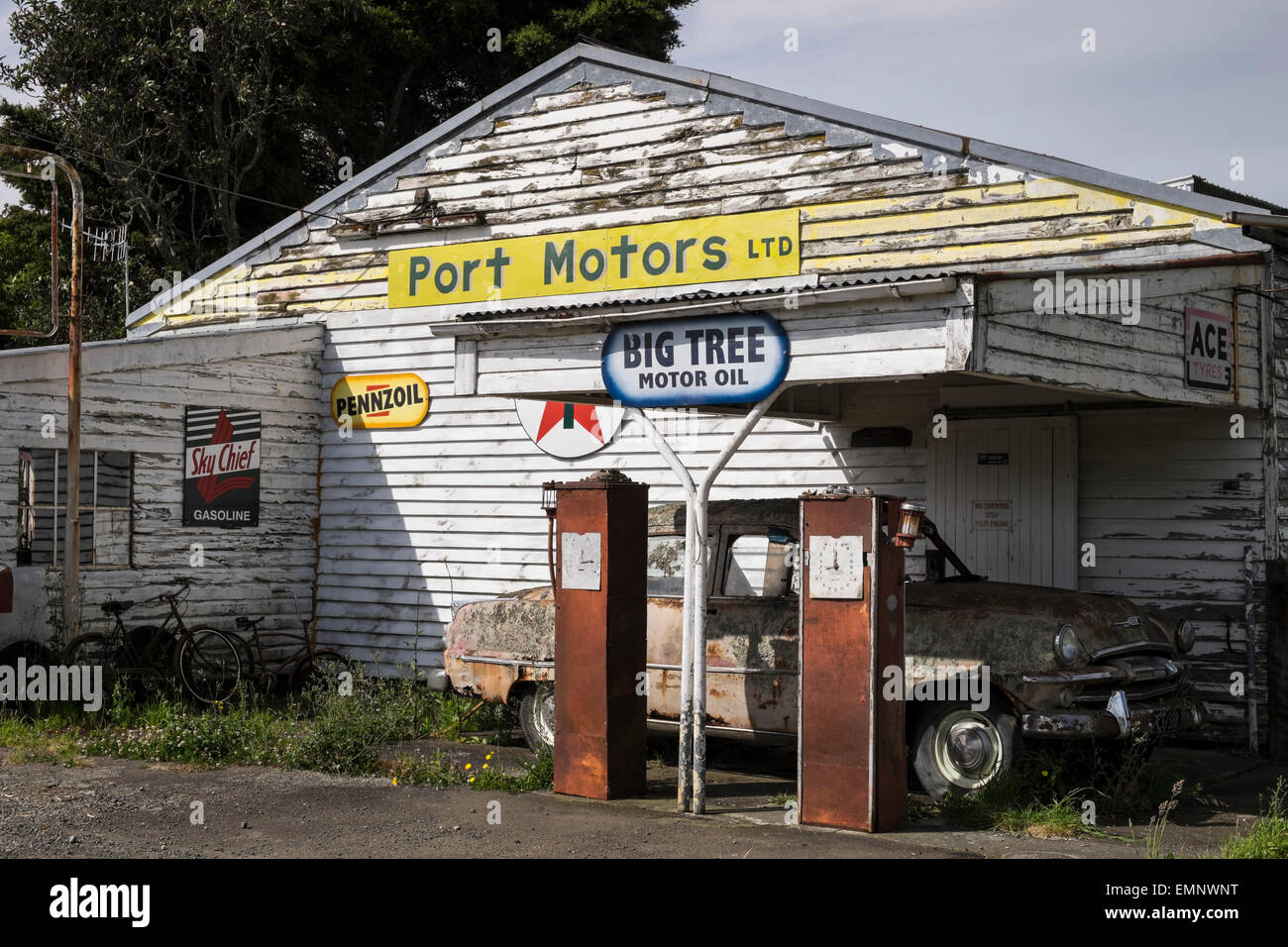 Old abandoned petrol station with a Plymouth Belvedere 1950s car, and two petrol pumps,  rotting on the forecourt. Ormondville, Stock Photo