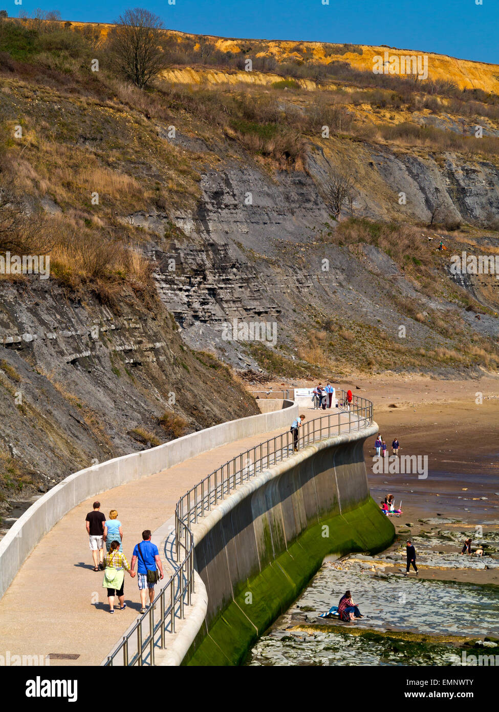 Tourists on the East Cliff coastal wall and sea defences at Lyme Regis