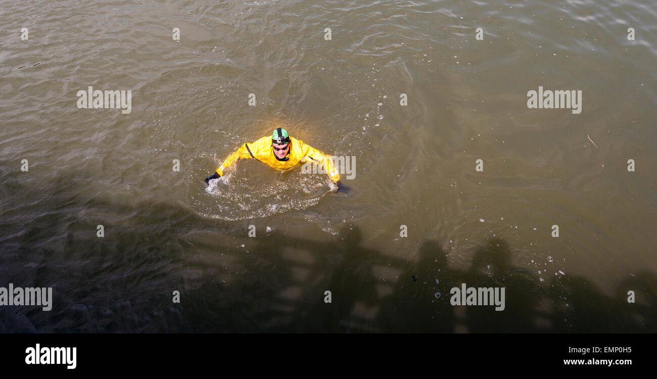 New York, USA. 22nd Apr, 2015. Donning his protective wetsuit, clean water activist Christopher Swain swims in the fetid waters of the polluted Gownus Canal in Brooklyn in New York on Earth Day, April 22, 2015. Swain's swim, swimming about a third of the canal, was to call attention for an accelerated cleanup of the waterway. The Gowanus Canal, which was completed in the late 1860's to facilitate industry along it's banks, became increasingly polluted until a pumping station was constructed at one end in the early 20th century to 'flush' out the canal. Credit:  Richard Levine/Alamy Live News Stock Photo