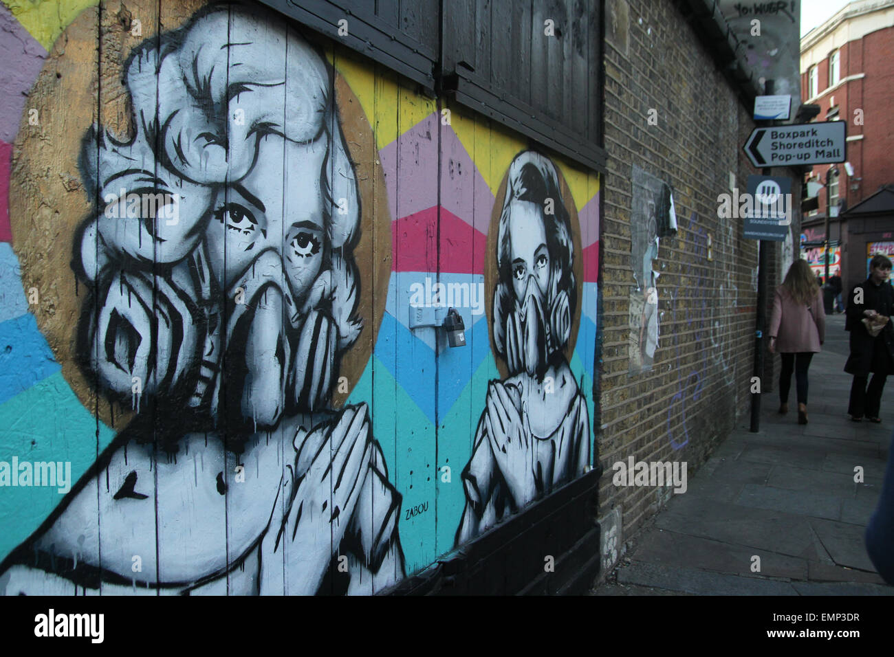 London, UK. 21 April 2015. People seen walking past a large graffiti mural on Brick Lane. Credit: David Mbiyu/ Alamy Stock Photo