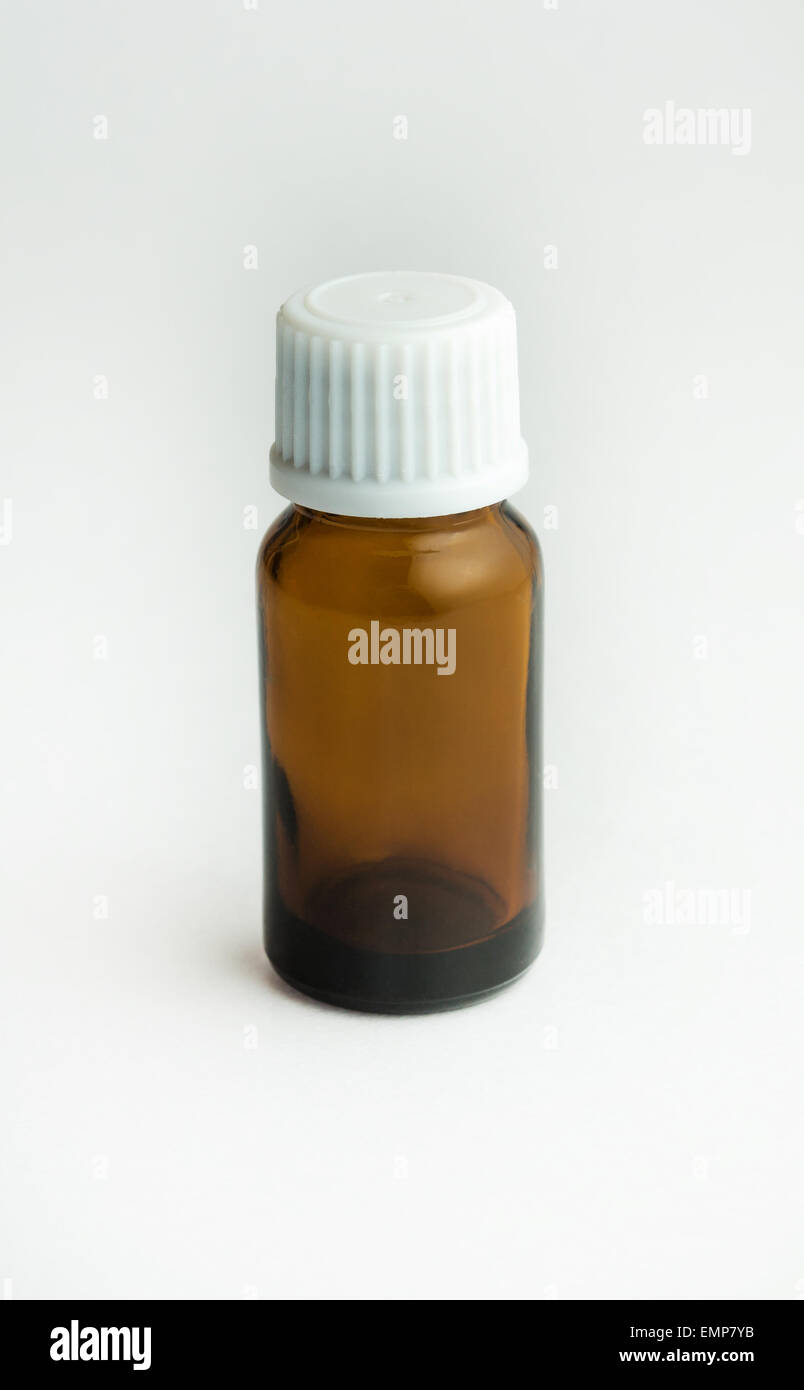 Small bottle from dark glass with a white cover and tablets. Stock Photo