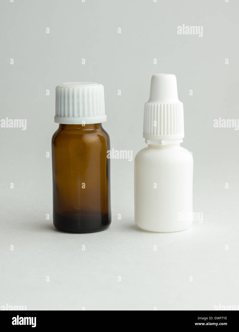 Small bottle from dark glass with a white cover and tablets. Stock Photo
