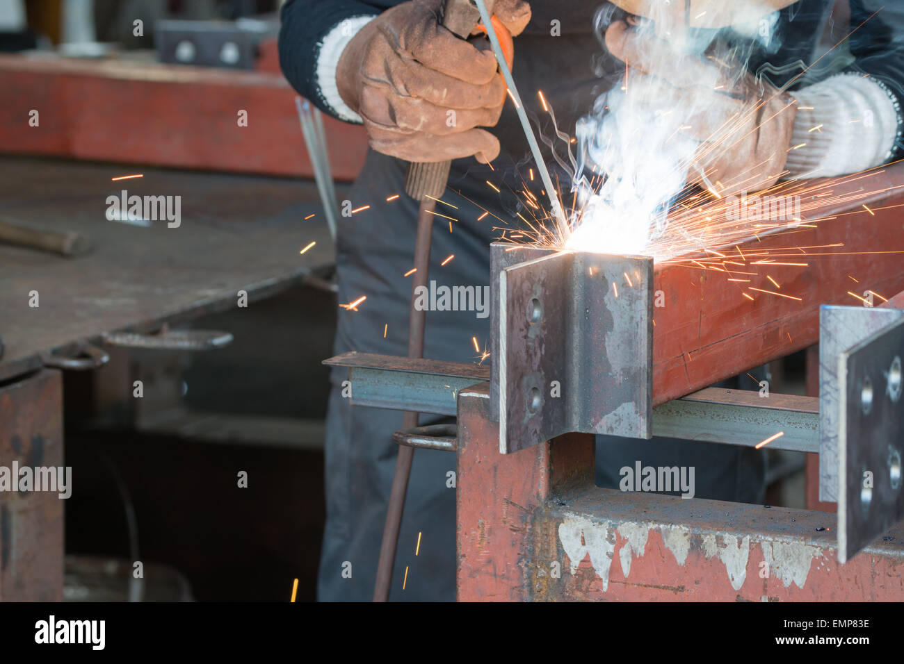 A welder welding creating sparks and smoke. Stock Photo