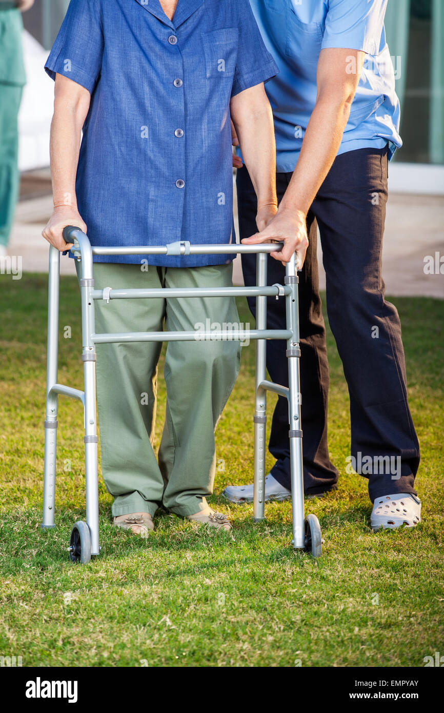 Caretaker Helping Senior Woman In Using Walking Frame Stock Photo Alamy