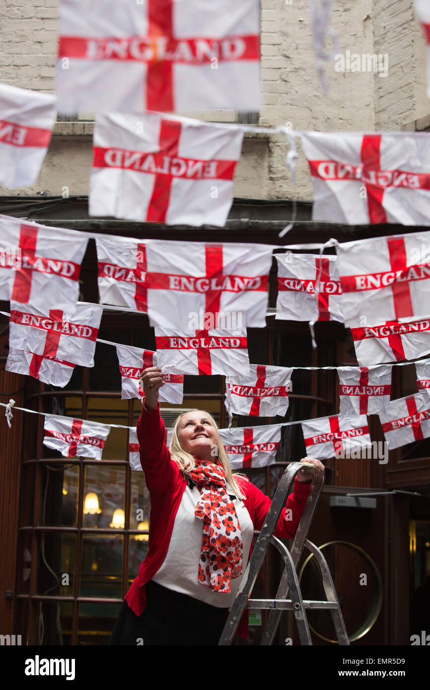 London, UK. 23 April 2015. Patricia Conway-Gravelius, waitress at Simpson's Tavern off Cornhill in the City of London, put up bunting for traditional St George's Day celebrations. Credit:  Nick Savage/Alamy Live News Stock Photo