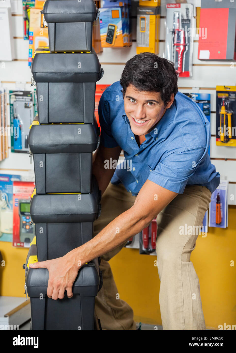 Man Carrying Stacked Toolboxes In Hardware Store Stock Photo