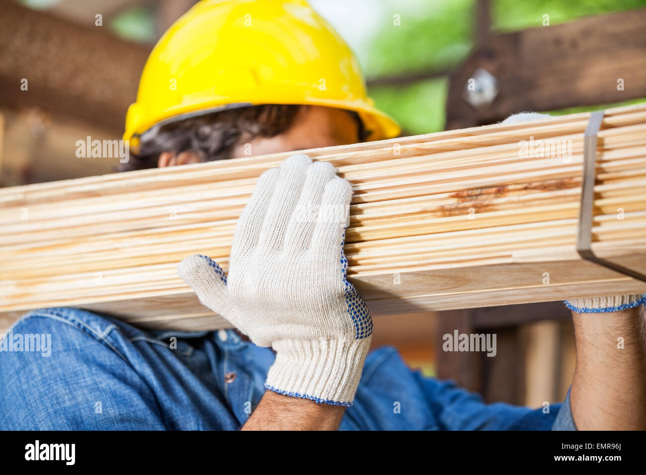 Worker Carrying Tied Wooden Planks At Construction Site Stock Photo - Alamy