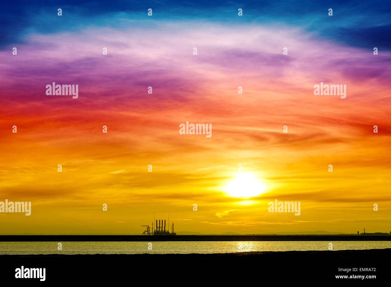 Colorful sunrise over industrial infrastructure in Swinoujscie harbor, Poland. Stock Photo