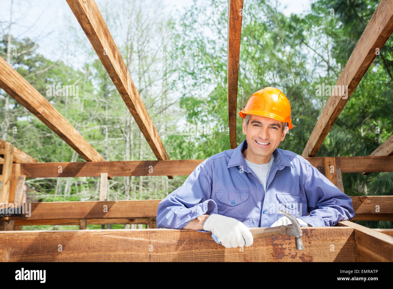Happy Construction Worker Holding Hammer At Site Stock Photo - Alamy