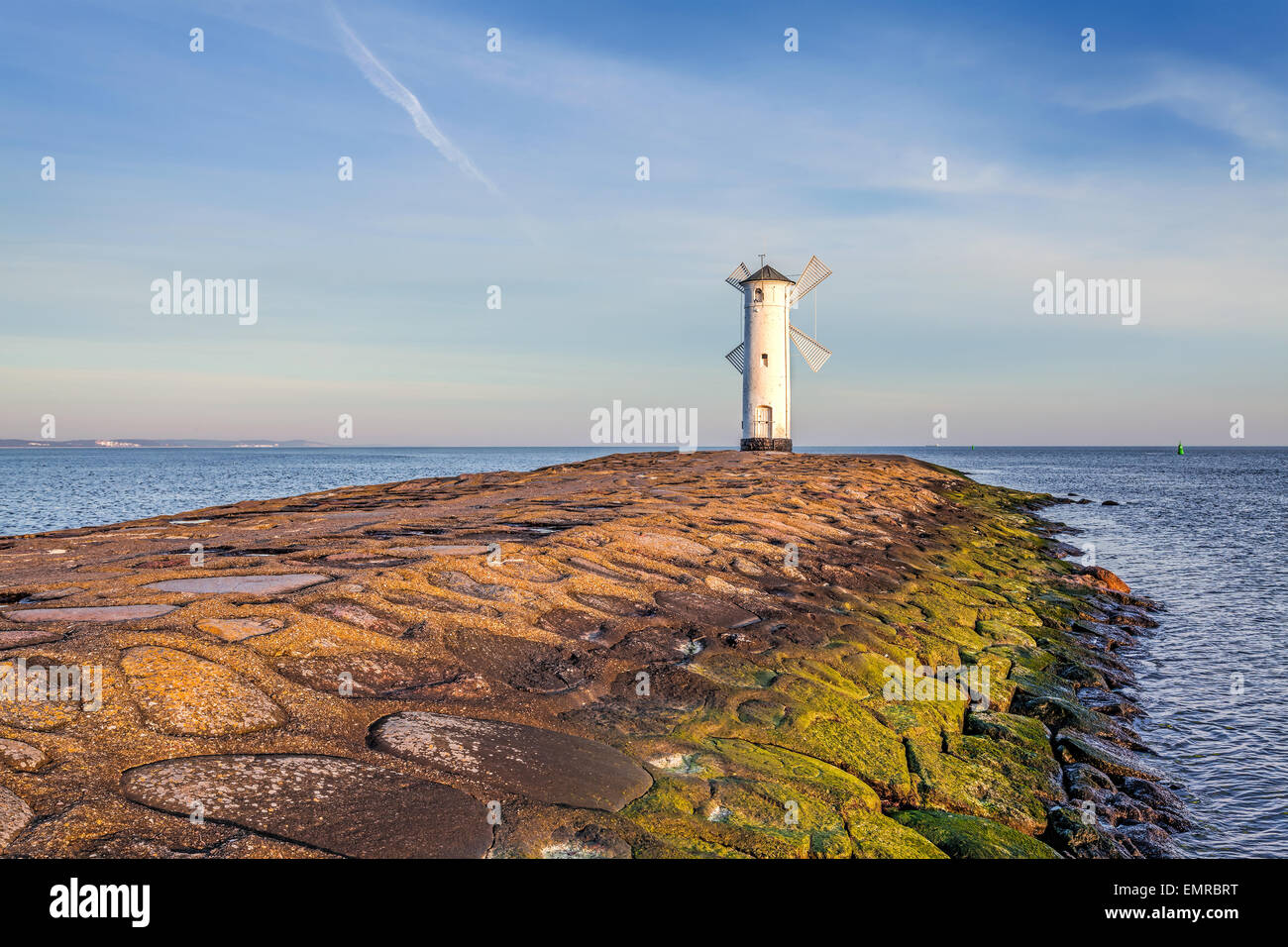 Vivid sunrise over pier and lighthouse in Swinoujscie, Poland. Stock Photo