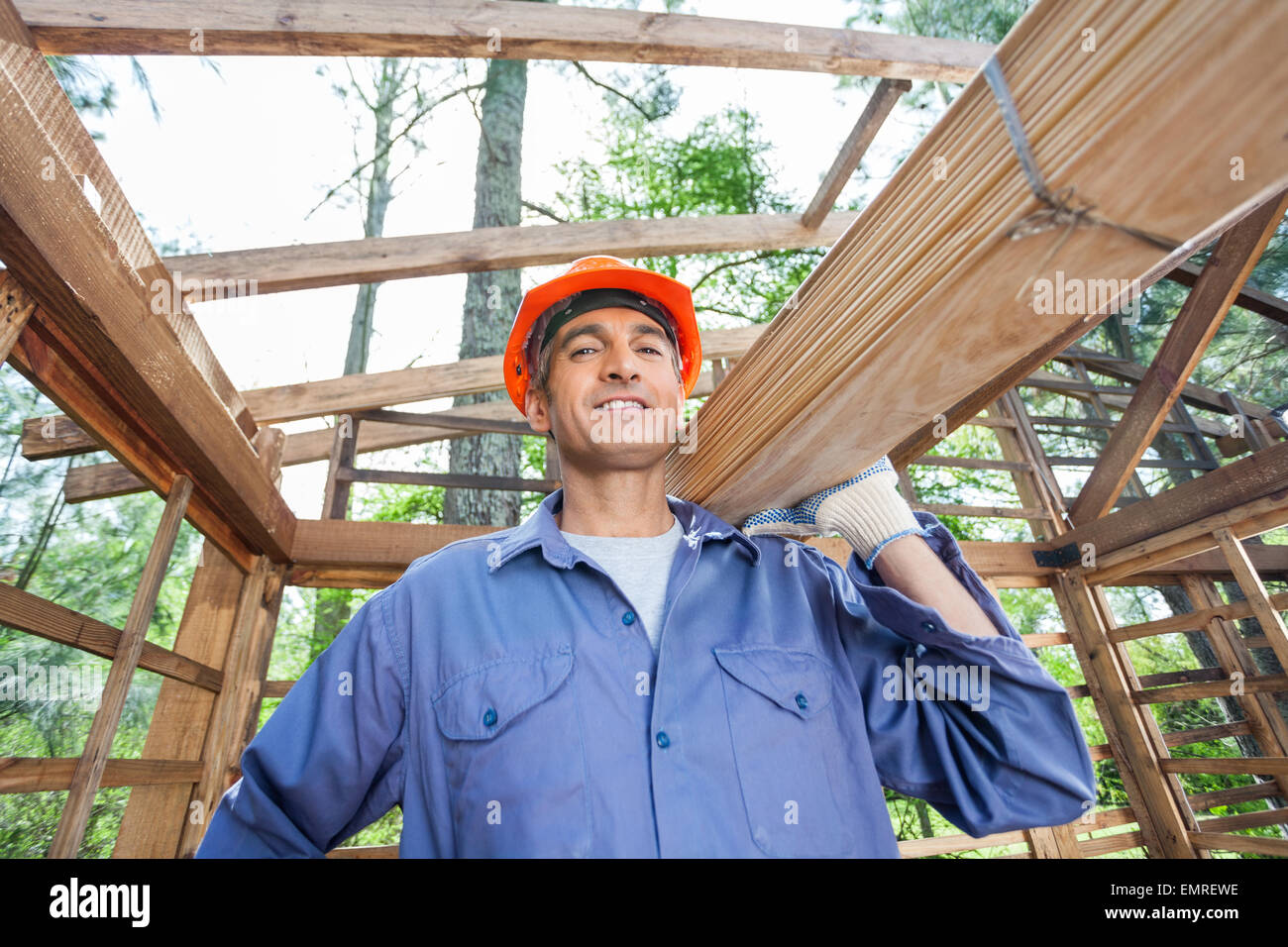 Smiling Construction Worker Carrying Wooden Planks Stock Photo - Alamy