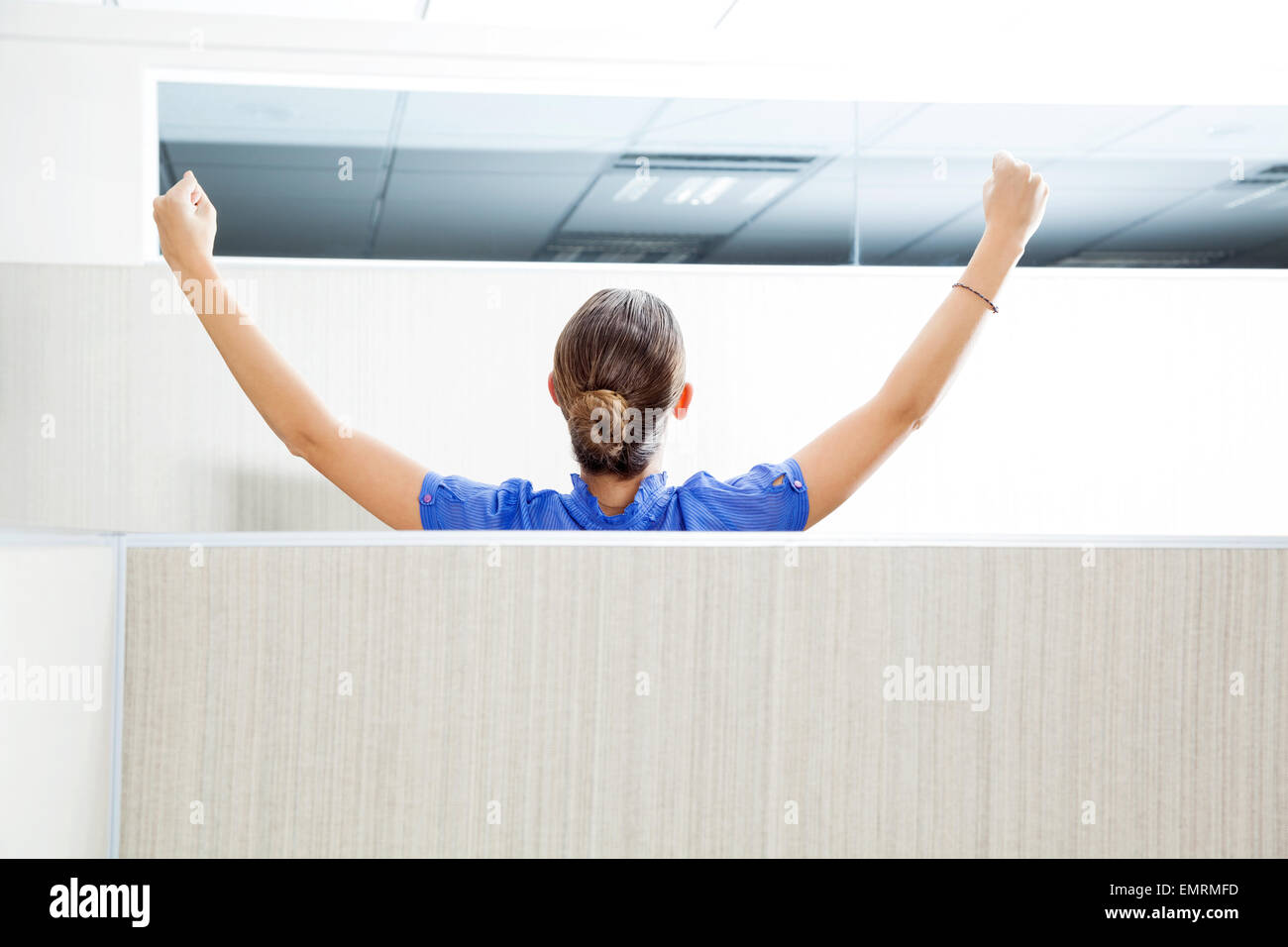 Customer Service Representative With Arms Raised In Cubicle Stock Photo