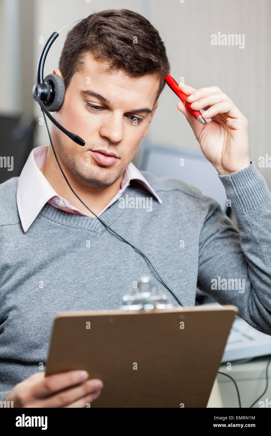 Confused Customer Service Representative Holding Clipboard Stock Photo