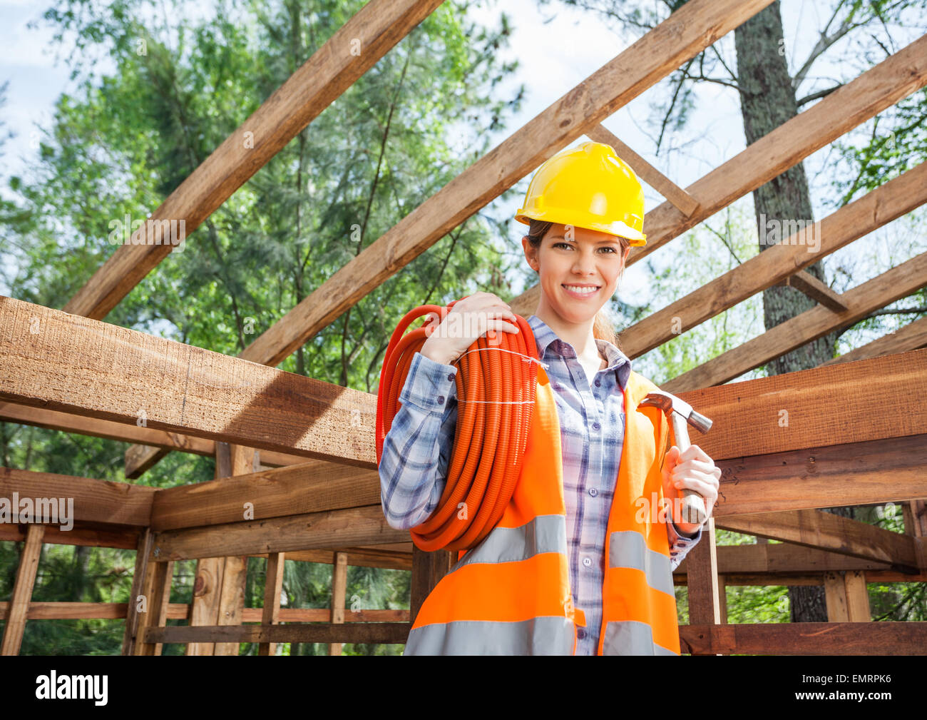 Female Construction Worker Holding Pipe And Hammer At Site Stock Photo ...