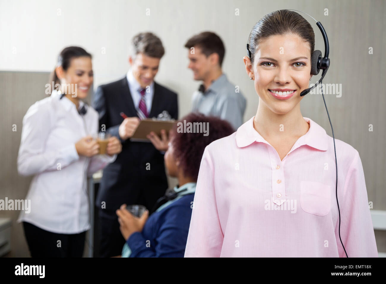 Beautiful Customer Service Representative Standing At Office Stock