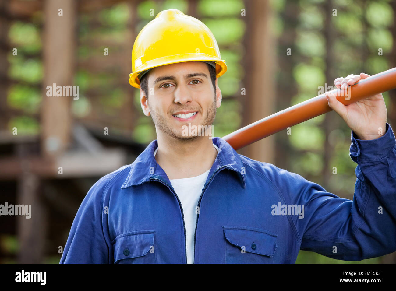 Happy Construction Worker Holding Pipe Stock Photo