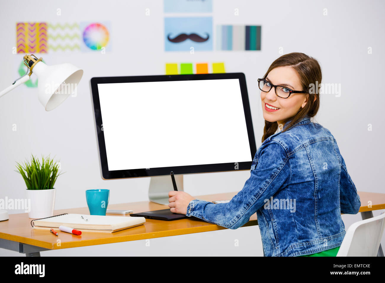 Woman working at desk In a creative office, using a computer Stock ...