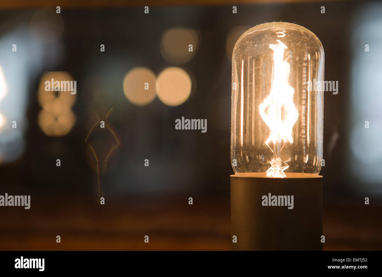 An glowing industrial lightbulb with bokeh Stock Photo