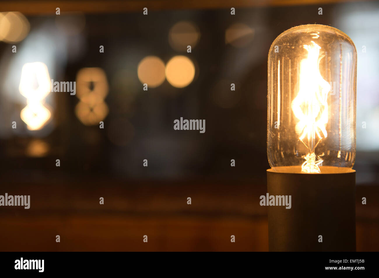 An glowing industrial lightbulb with bokeh Stock Photo