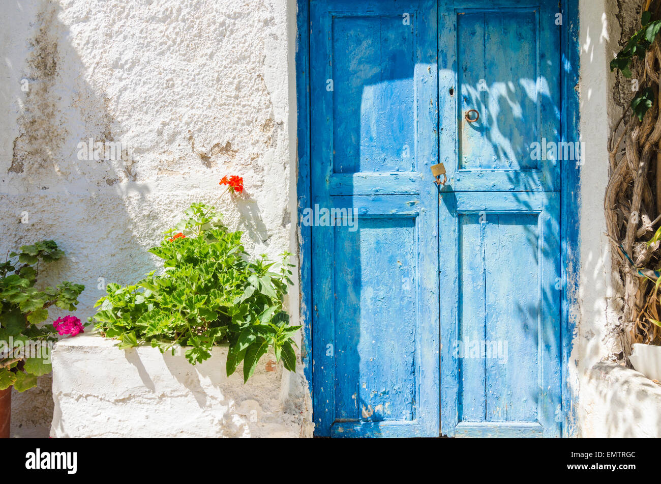 Old faded blue wooden doors on a white-washed building in Naxos, Greece Stock Photo