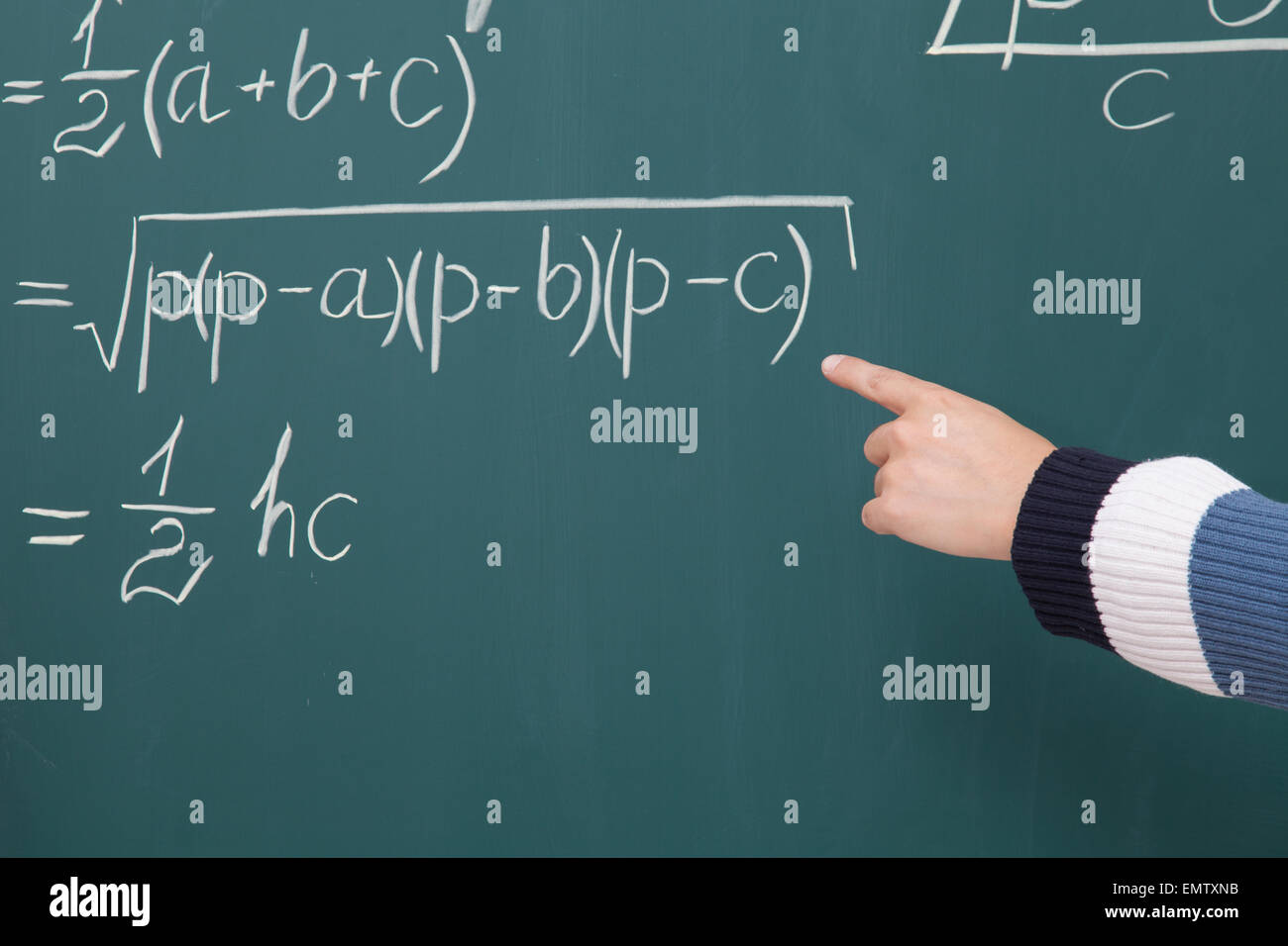 Trainee solve math problems written in chalk on the blackboard Stock Photo
