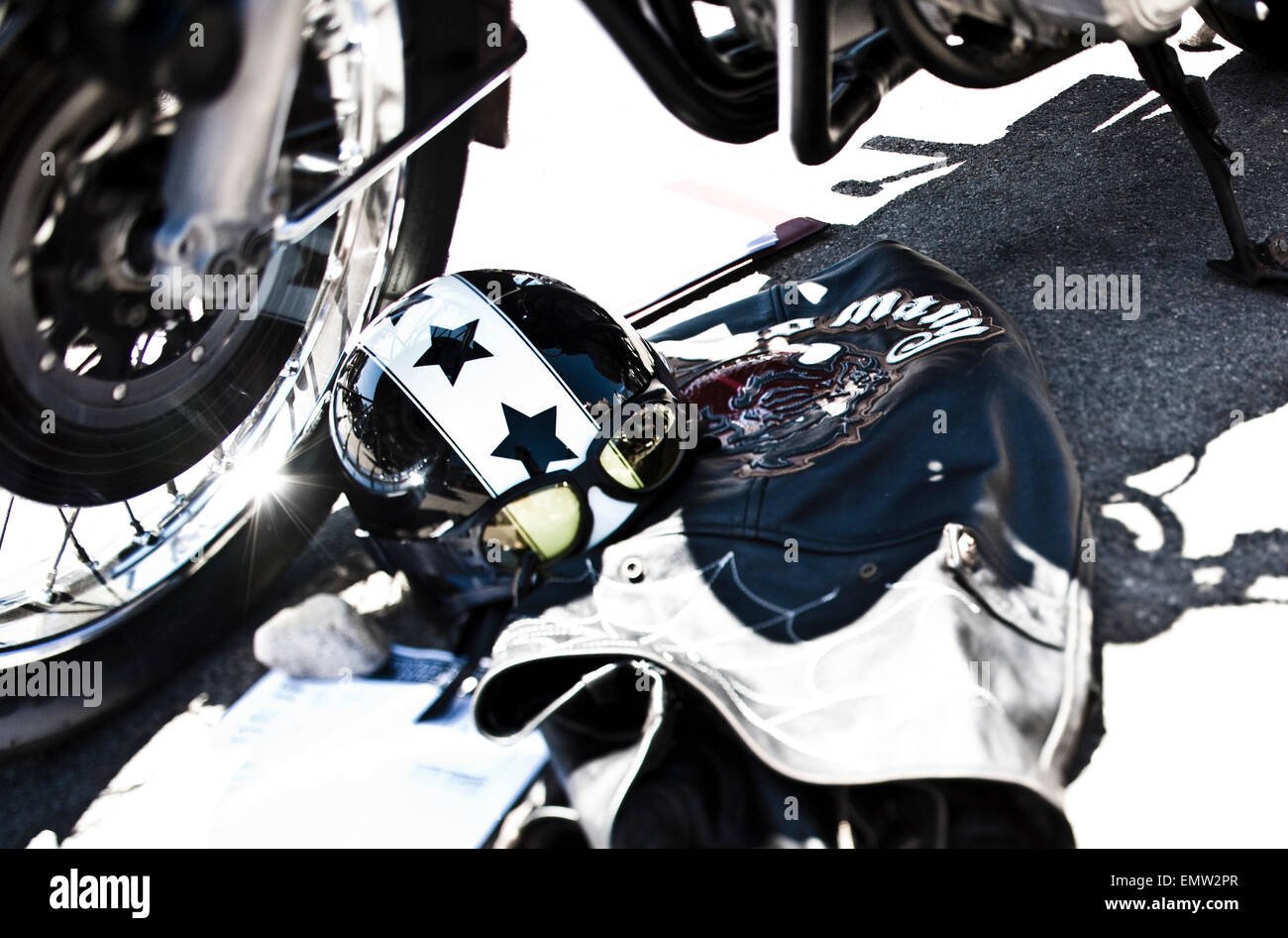 The custom painted helmet and goggles with a leather jacket on the ground next to a motorcycle in Venice, California. Stock Photo