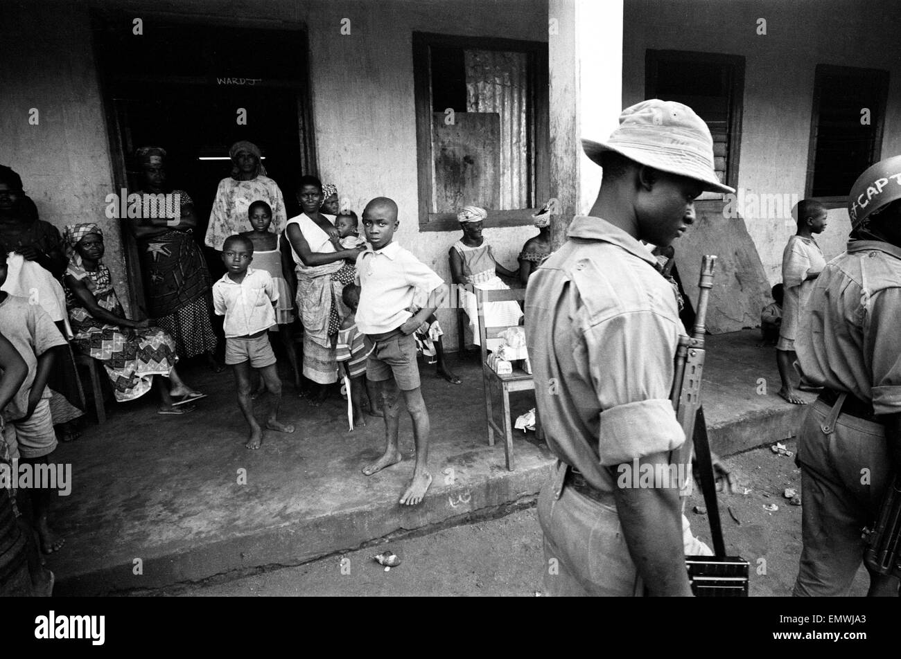 Pictures taken during the Daily Mirror's attempt to reach the refugee camps of Onitsha and Asaba during the Biafra conflict. Women and children watch soldiers walk by in the camp. 16th July 1968. Stock Photo