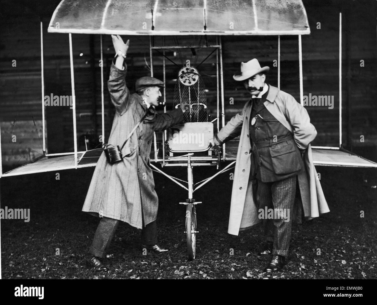 The flying machine of Mr E Mines, engineer, seen here at the Doncaster flying meeting. Edgar Wallace (pipe) and journalist harold Ashton seen here discussing the best way to steal the machine . 20th October 1909 Stock Photo