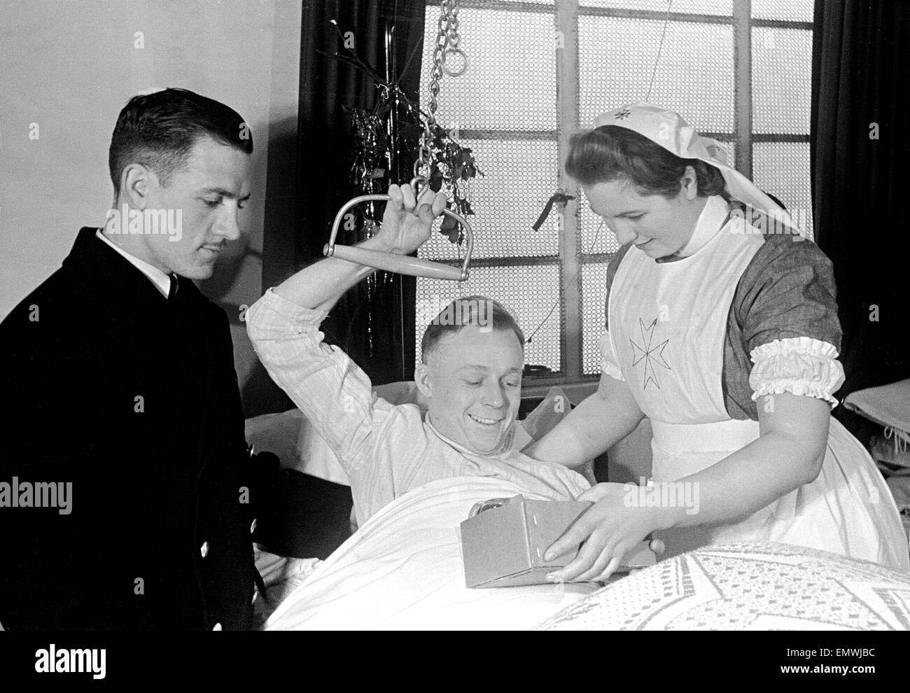 LA Fireman, A.H Watkin receives Christmas present from the Benevolant Fund at the Royal National Orthopeadic Hospital, 23 December 1941 Stock Photo