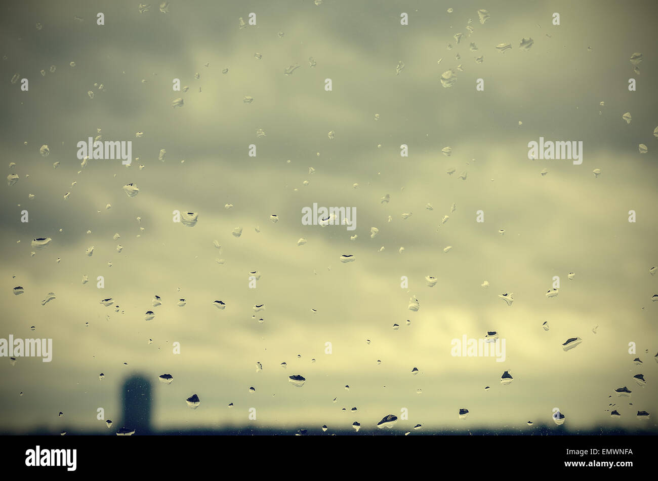 Retro filtered abstract background made of rain drops on window. Stock Photo