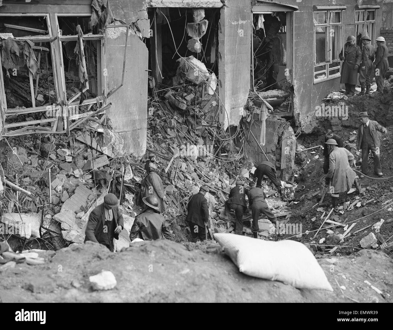 Workman and rescue workers search through the rubble and shell of the