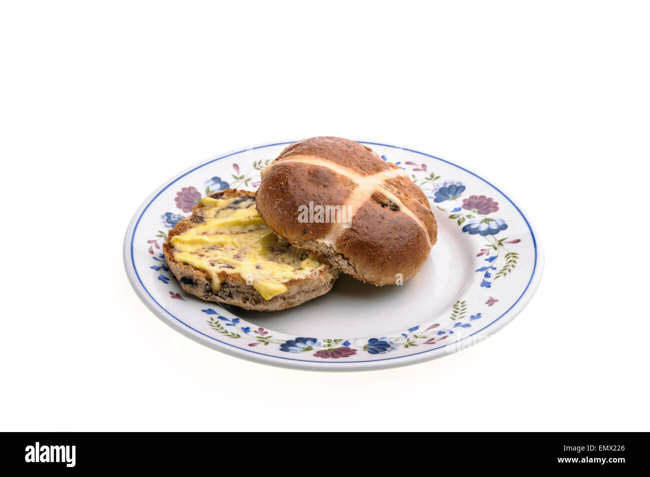 Hot cross bun on a round, decorated plate. Stock Photo