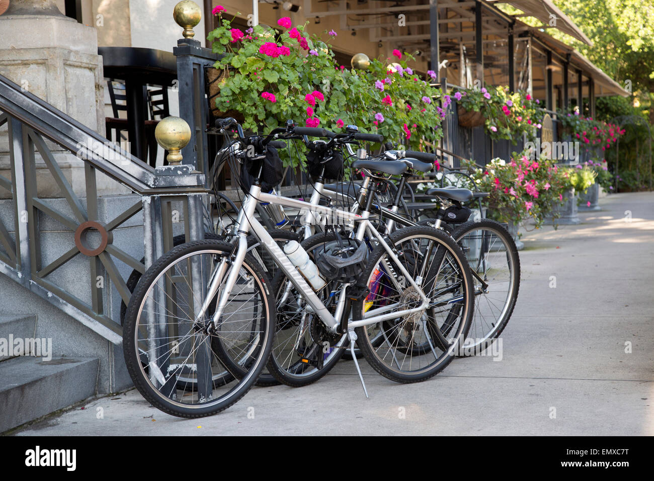 Bikes parked along sidewalk in front of restaurant with flowers in Old Naples Stock Photo
