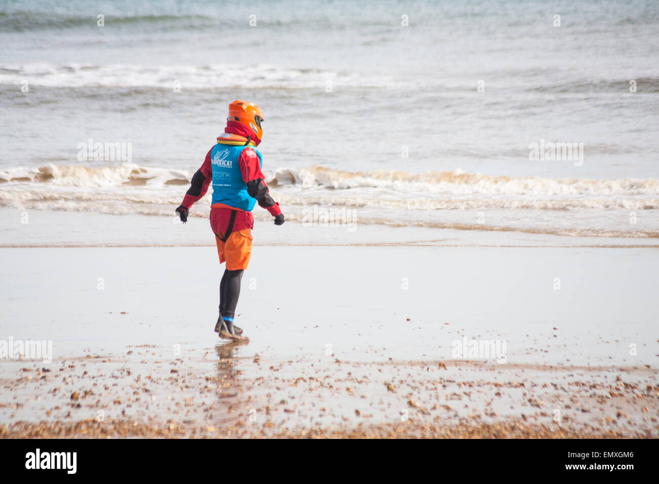 Man in helmet and safety gear walking into the sea  for the ThunderCat Racing UK at Boscombe beach, Dorset, UK in April Stock Photo