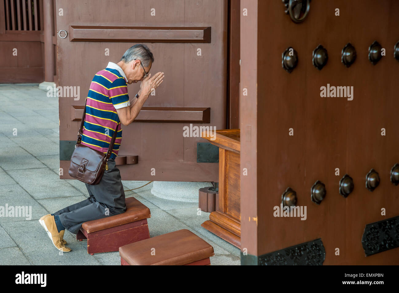 Chinese Man praying in a monastery in Hong-Kong Stock Photo