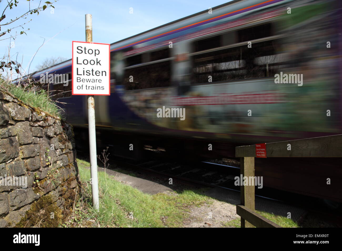 A train passes through a pedestrian level crossing near Uppermill Saddleworth Oldham England UK Stock Photo
