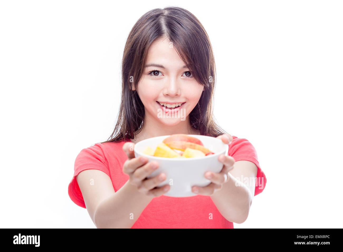 Young Chinese woman holding bowl of fruit to the camera Stock Photo