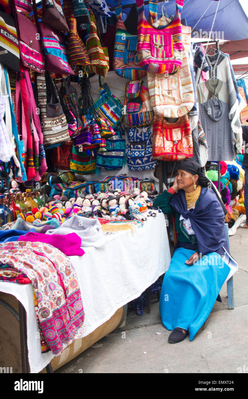 Merchant with products on display for sale at Otavalo market, Ecuador Stock Photo