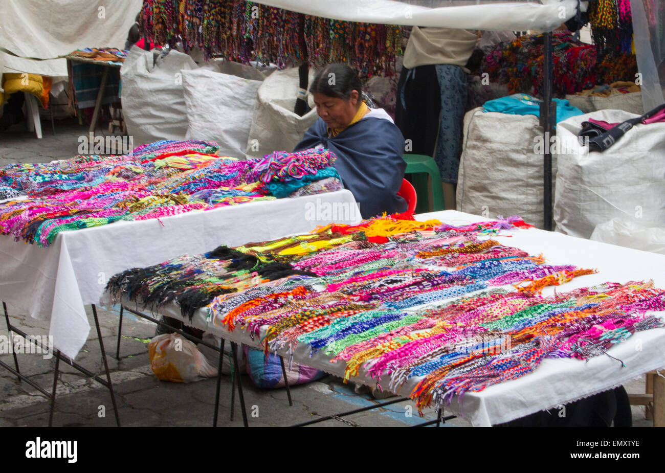Female merchant with merchandise on display for sale at Otavalo market, Ecuador Stock Photo