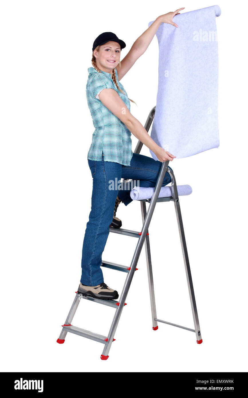 Woman putting up wallpaper Stock Photo Alamy