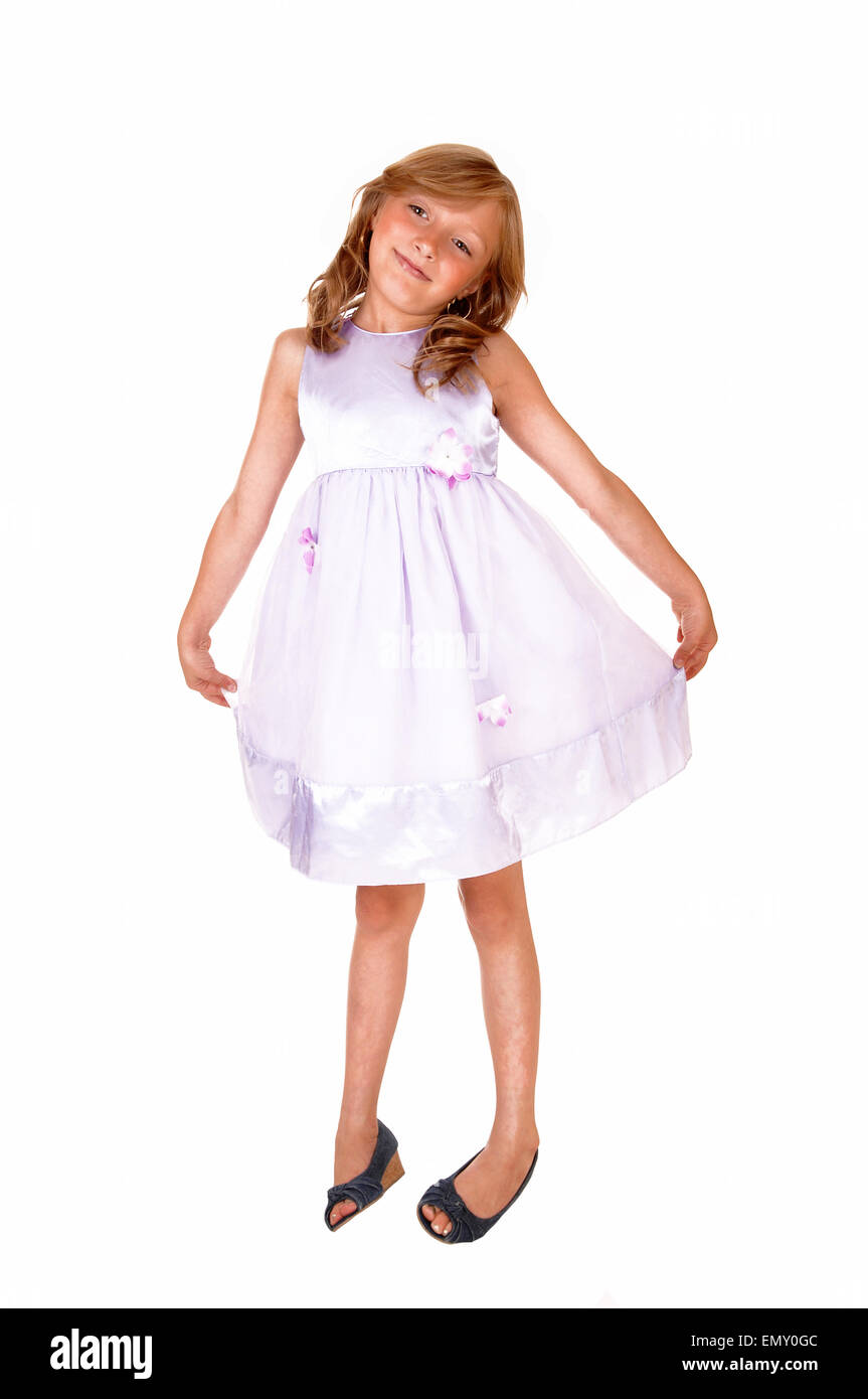 A lovely young girl in a pink dress posing for a picture, standing ...