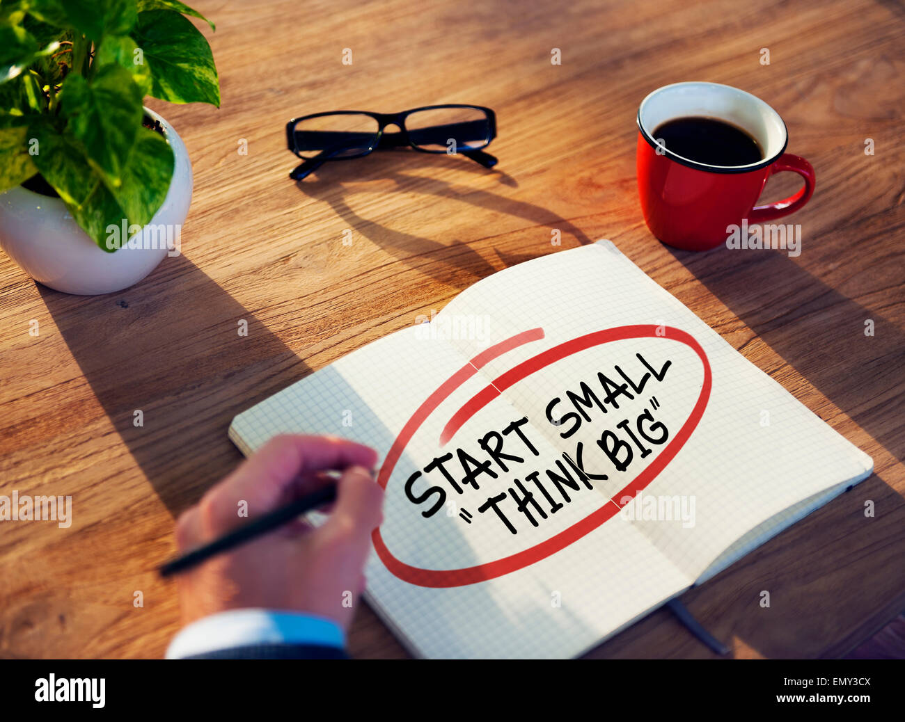Businessman Writing the Words 'Start Small Think Big' Stock Photo