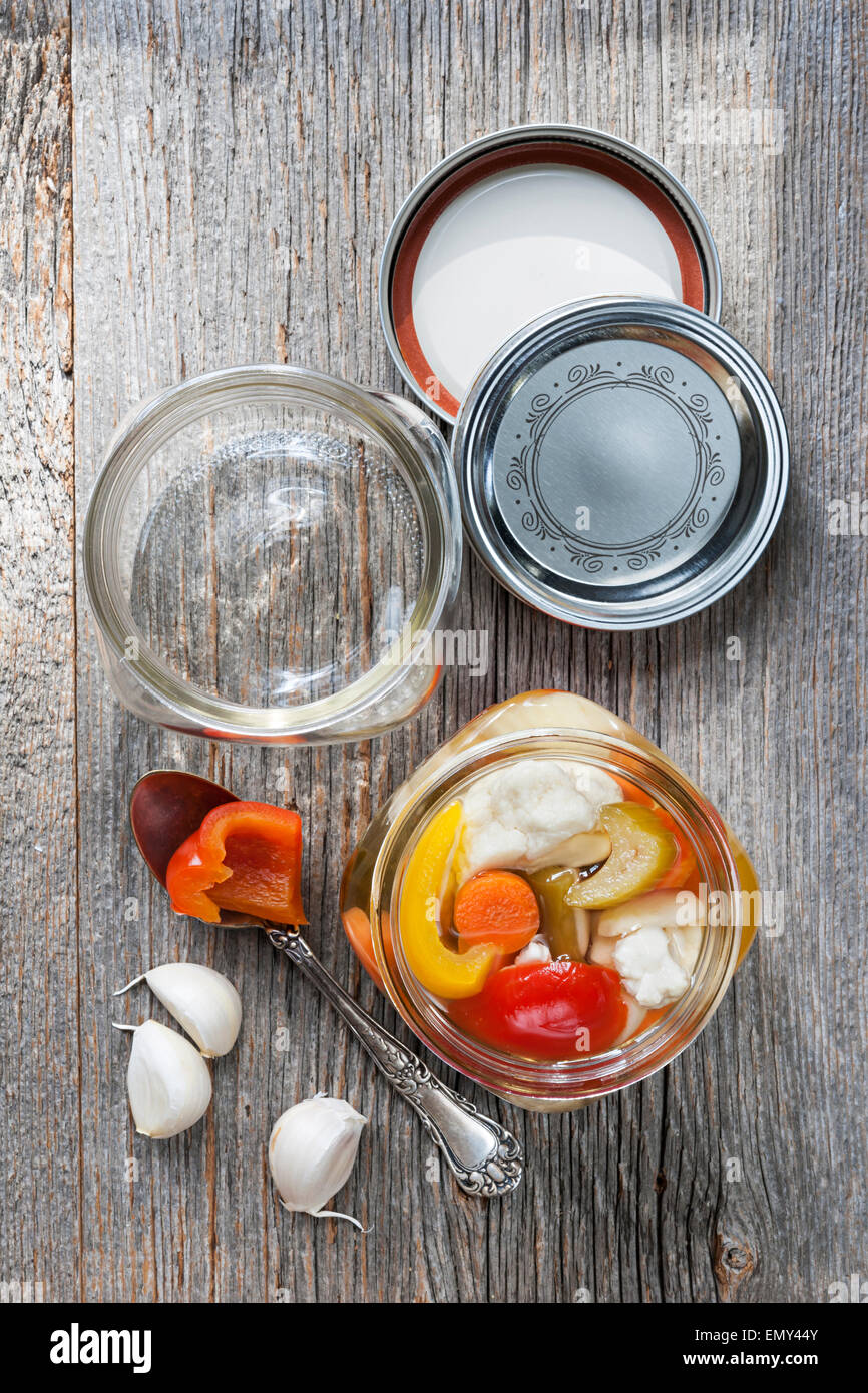 Home preserving mixed vegetables by pickling in glass canning jars Stock Photo