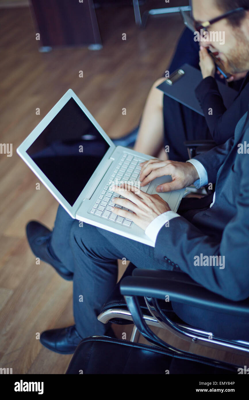 Male employee typing at working seminar or conference Stock Photo - Alamy