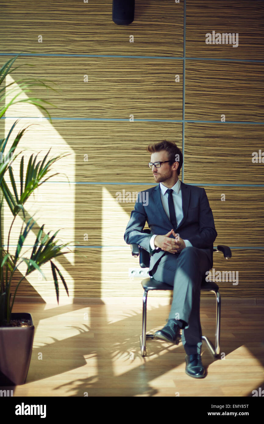 Elegant businessman sitting on chair Stock Photo - Alamy