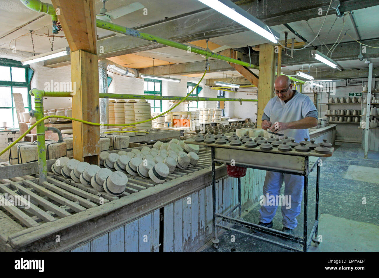 A male potter working on lids at the Burleigh Middleport pottery
