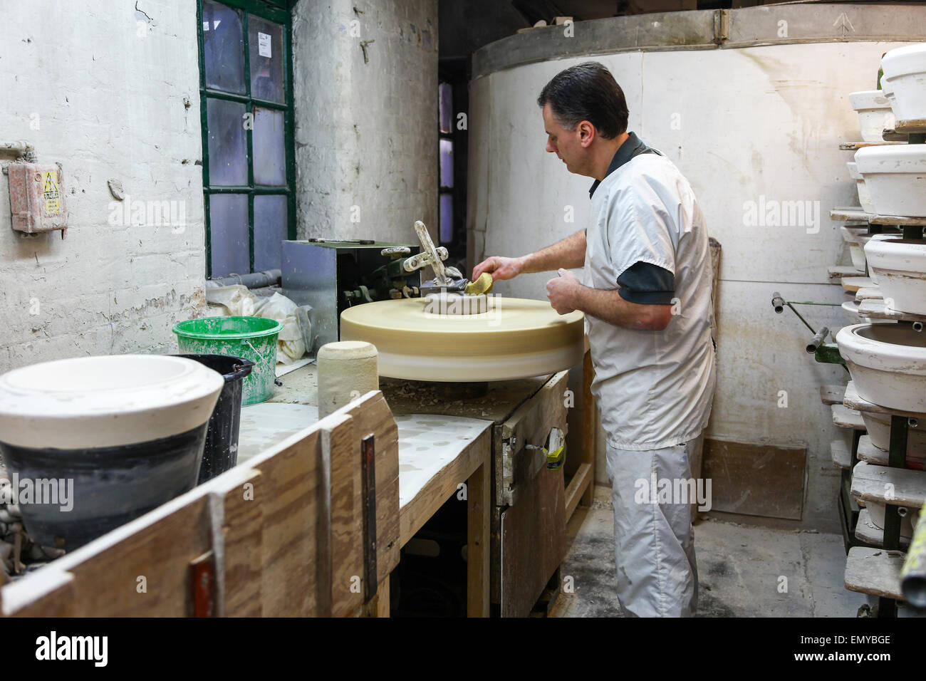 A potter working clay on a potters wheel Burleigh Middleport pottery factory Stoke-on-Trent North Staffordshire England UK Stock Photo