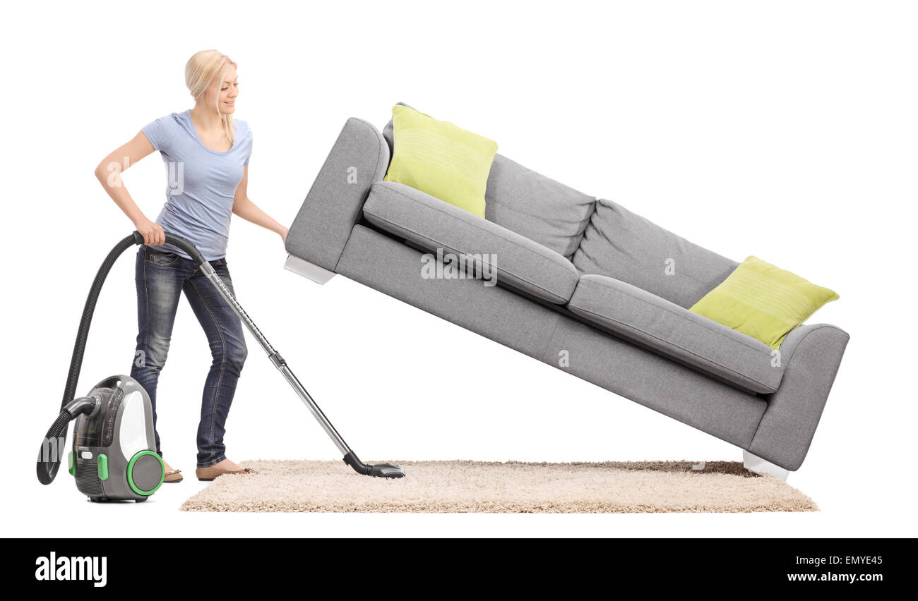Strong housewife lifting a sofa with one hand and vacuuming underneath it isolated on white background Stock Photo