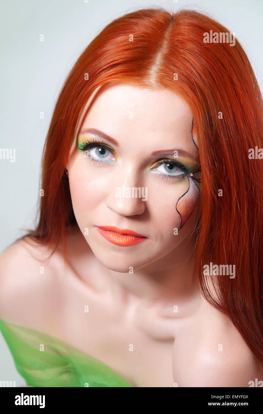 Portrait of beautiful red-haired girl with a flower painted on his face Stock Photo