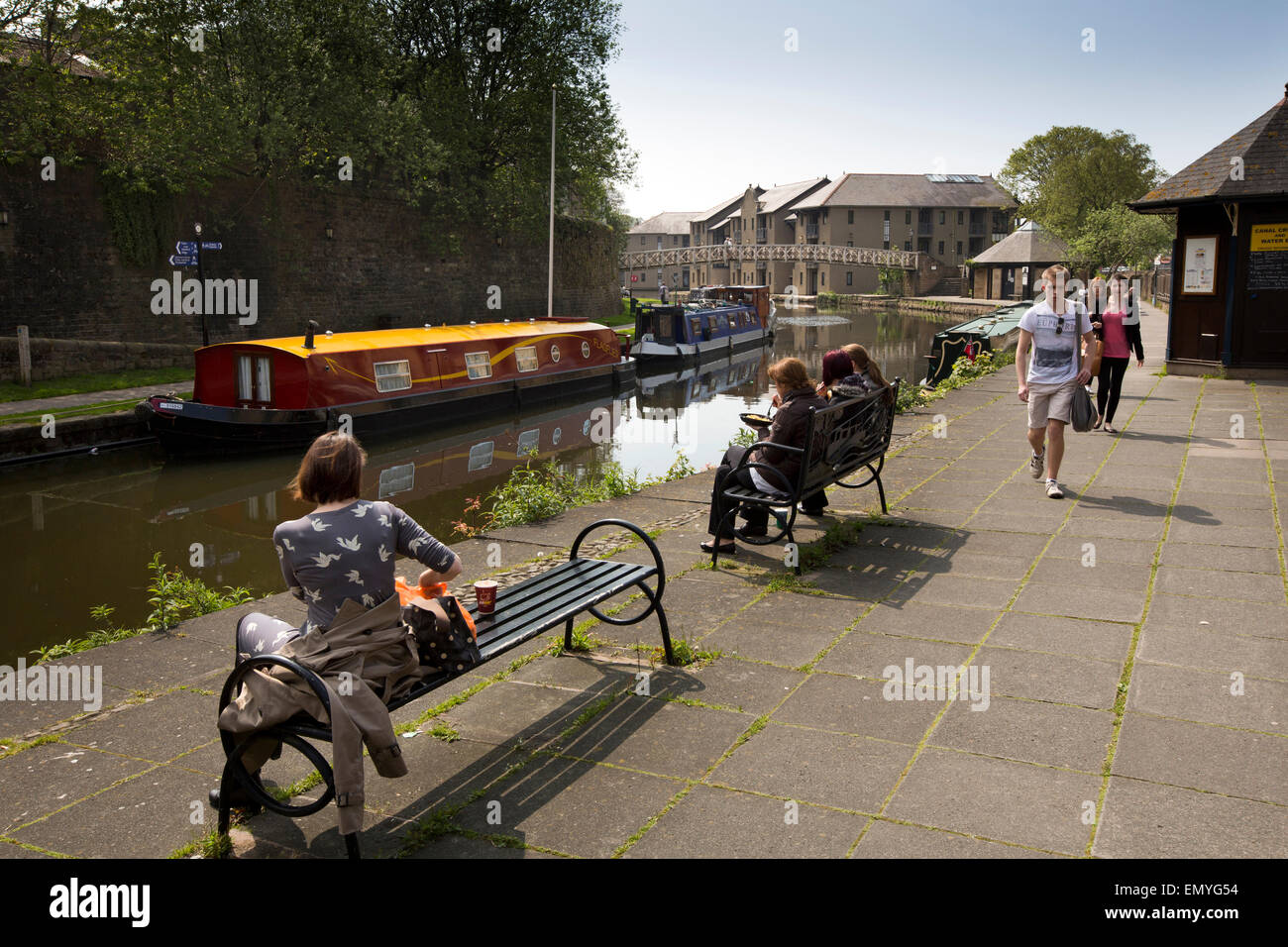 UK, England, Lancashire, Lancaster, people relaxing in sunshine beside Canal at Penny Street Bridge Stock Photo